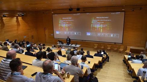 Lecture theatre full of attendees of the CGC and EE anniversary event listening to talks.